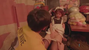 Một người phụ nữ trung niên có thân hình cân đối đang hé mặt và thực hiện động tác thổi kèn. Cô của cô ấy ngậm sâu và hôn môi, đầy quyến rũ và cám dỗ